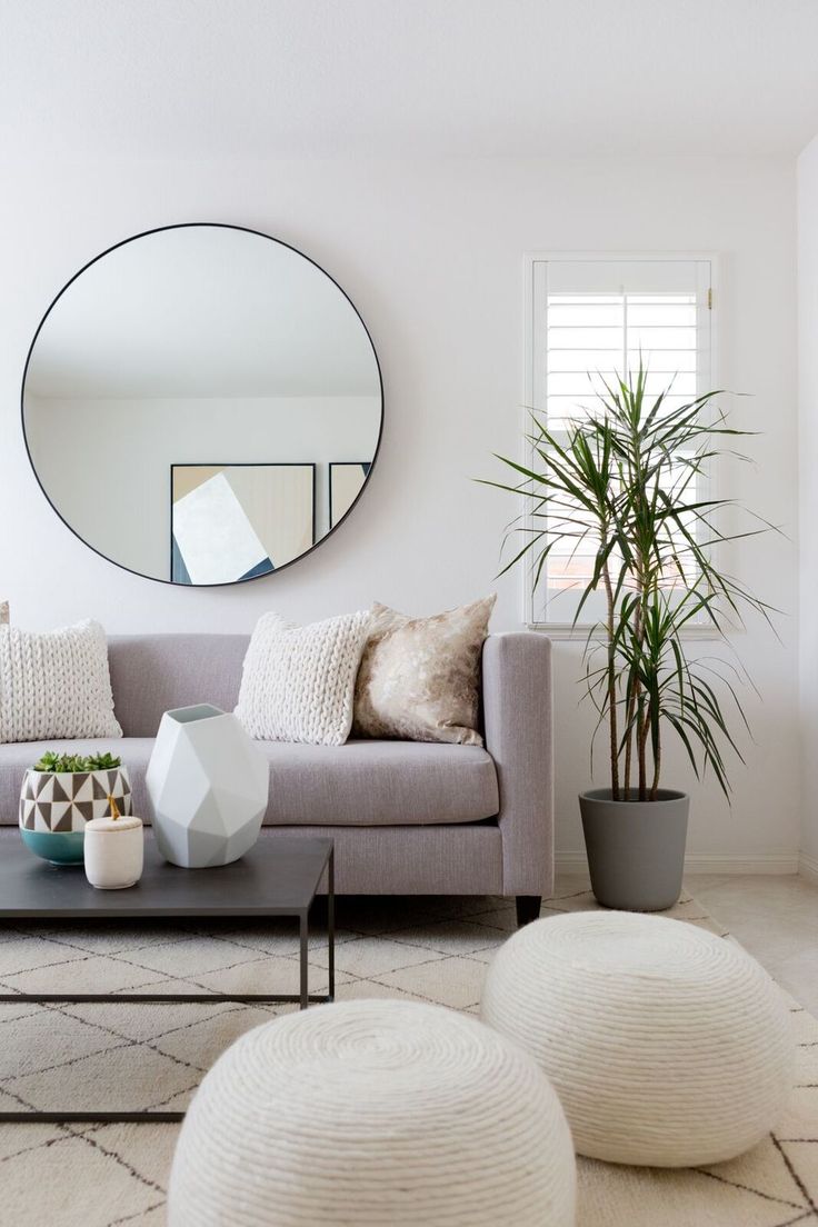 Round mirror, grey linen sofa, rope coil ottomans, plant, modern geometric…