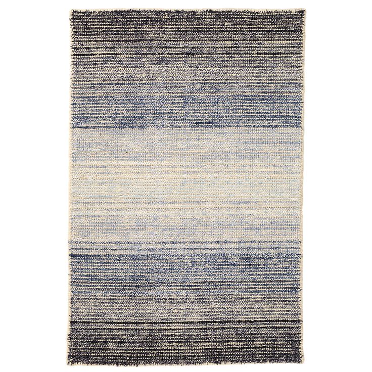 Be transported with this woven wool/viscose area rug in varying shades of a…