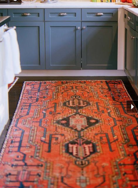 love those blue lower cabinets with red persian rug and dark hardwood floors.