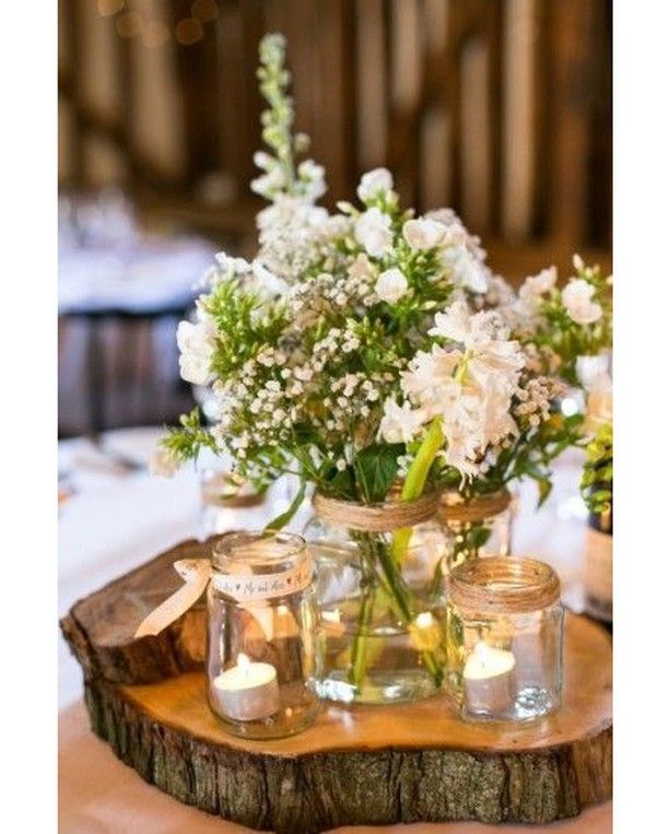 Centro de mesa floral con tarros de cristal velas y un tronco como base Ideal!#i...