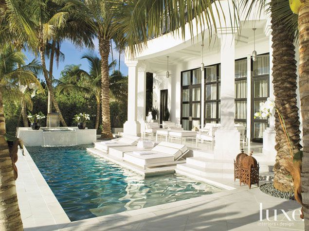 White alabaster stone covers this patio, extending into the pool making lounging...