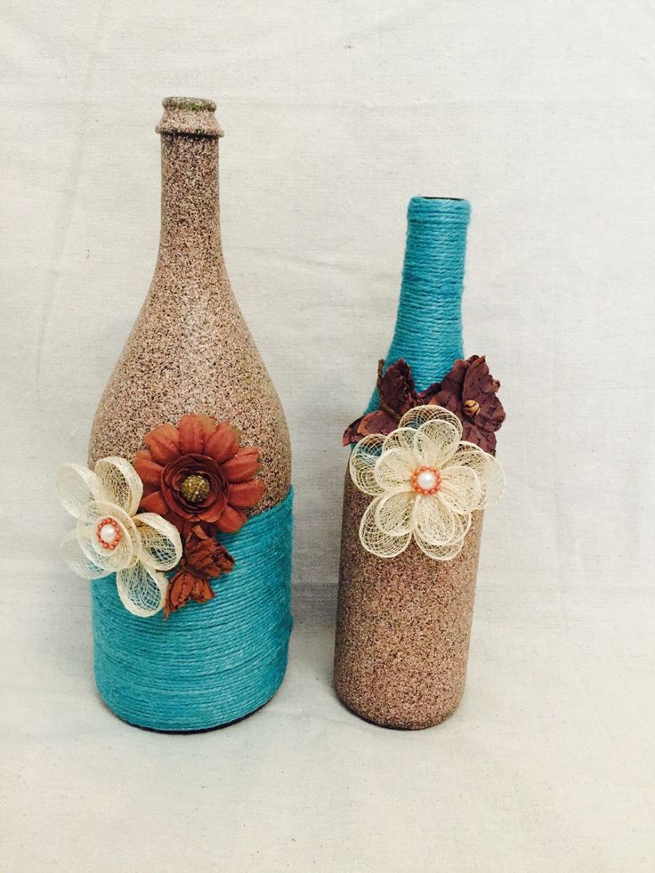 Stone and teal rustic wine bottles with flower and butterfly accents for home or wedding
