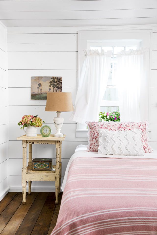 In Guest Bedroom #1, rustic shiplap walls are the perfect foil to the sweet pink...