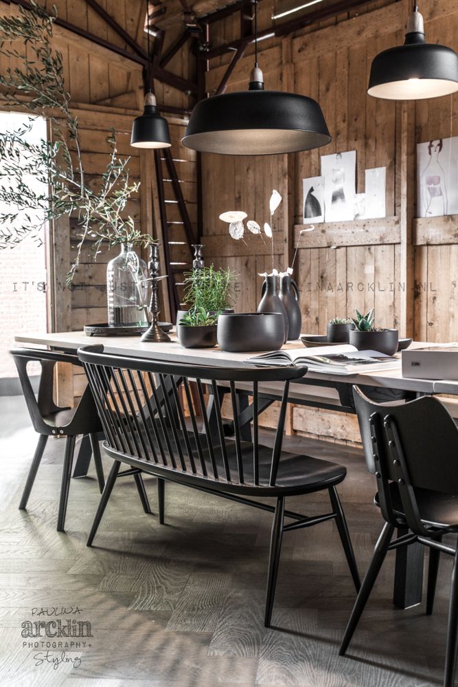 Dining area in black and wood in a barn photographed by Paulina Arcklin