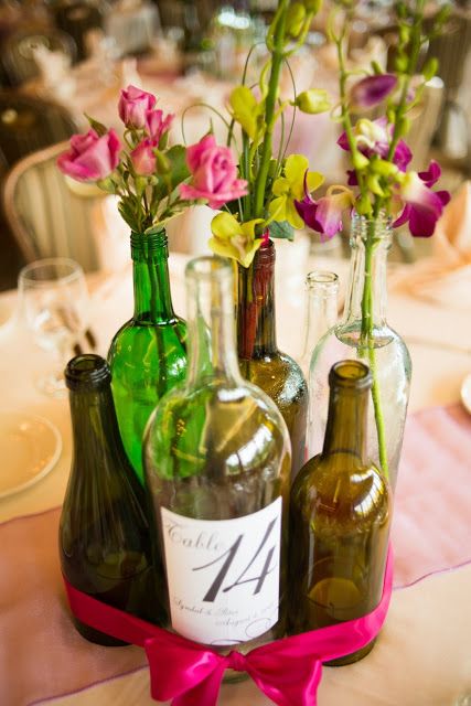 Wine bottle centerpiece with candles inside, flowers and table number.  Then tie...