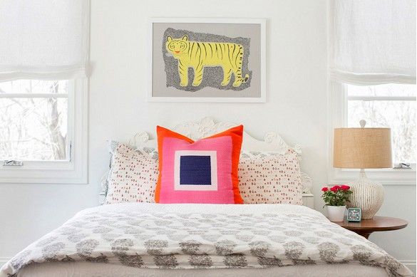 Artful bedroom with simple artwork and vibrant pillow