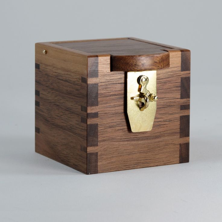 Custom ring box with a brass latch. The lid swings open and the interior has a f...