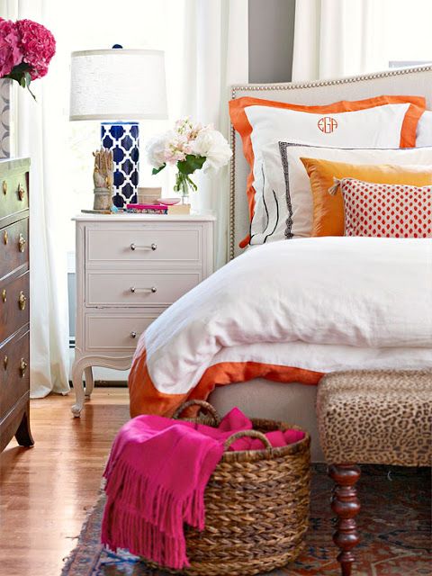 A white bedroom with blue, orange and pink pops of color. This space is so comfo...