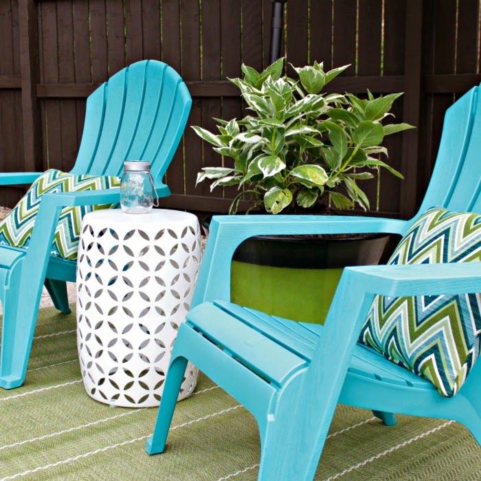 brightly colored adirondack chairs look great against a dark fence