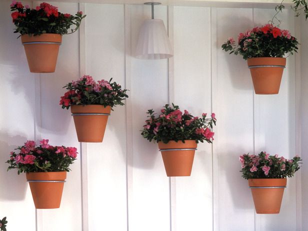 Vertically mounted flower pots create a charming spot for more gardening.
