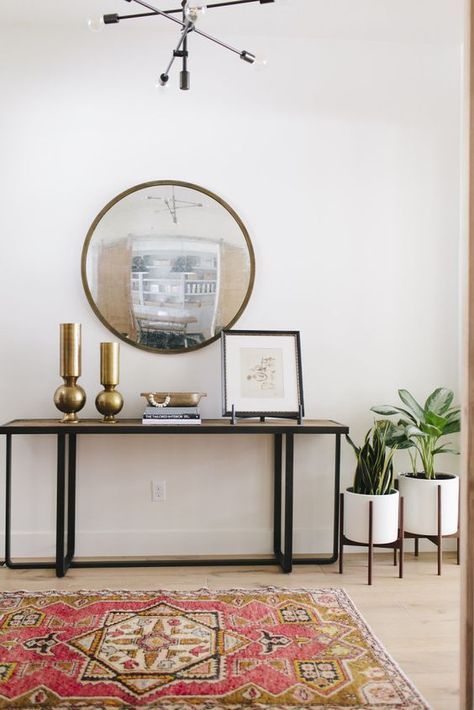 loving that round oversized mirror over the side table in entryway