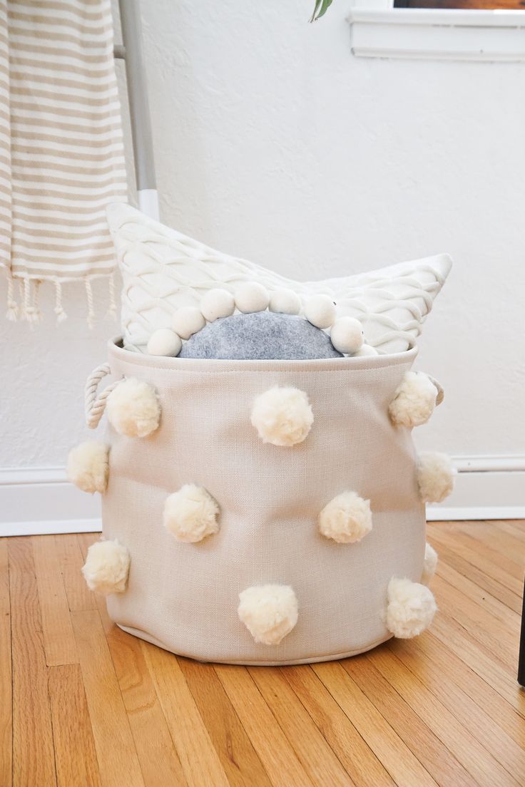 Love neutrals? This DIY fluffy pom pom bin provides a nice bit of texture while ...