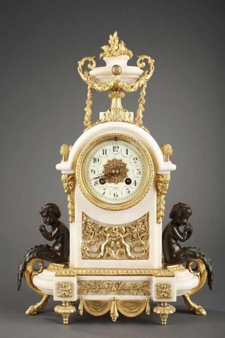 A Louis XVI style marble and bronze mantel clock with Cupids