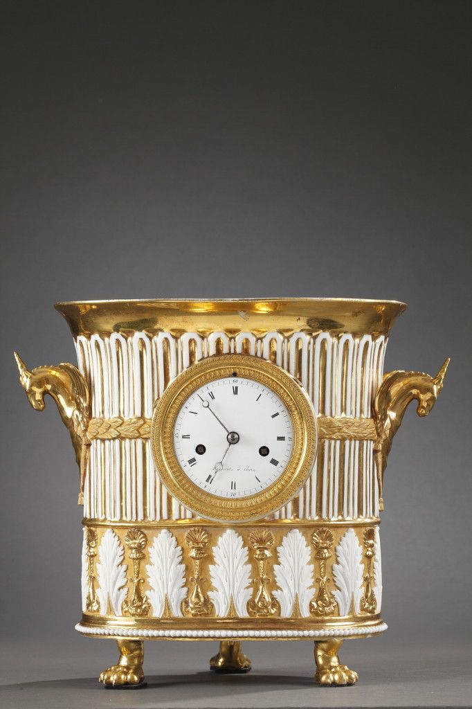 Vase-shaped mantel clock in gilded porcelain. Breguet hands track the hours and ...