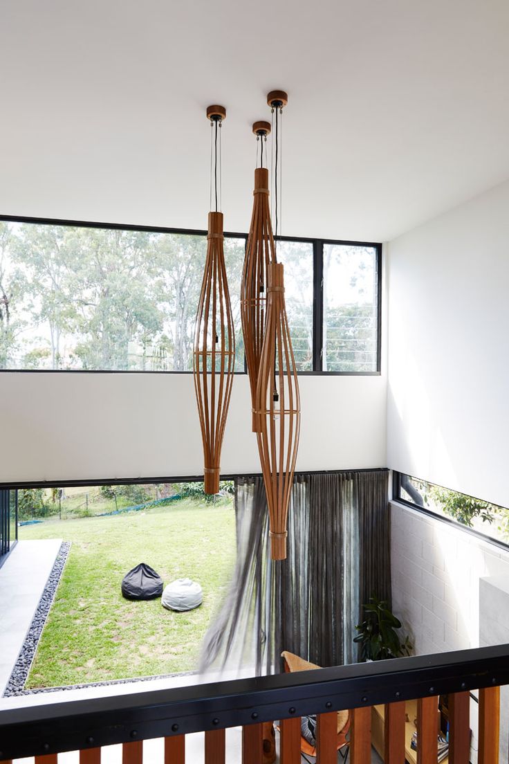 The entryway in this modern house overlooks the living room and backyard, and pr...