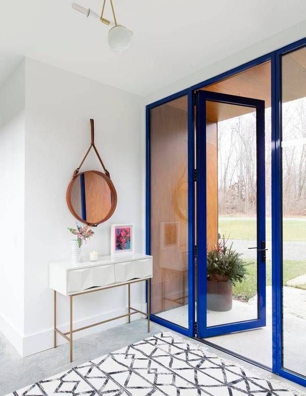 modern blue doorframe paired with graphic black and white rug