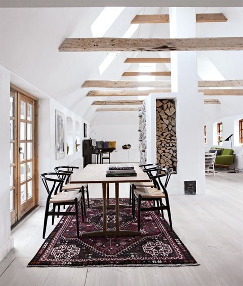 purple rug in dining room with exposed wood beams in vaulted ceiling