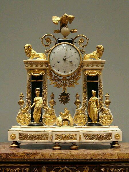 Reloj figurativo de bronce dorado y base de mármol blanco,  1780.
