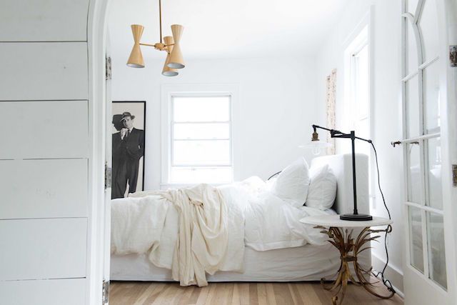 A white bedroom in the beautiful farmhouse of interior designer Leanne Ford.