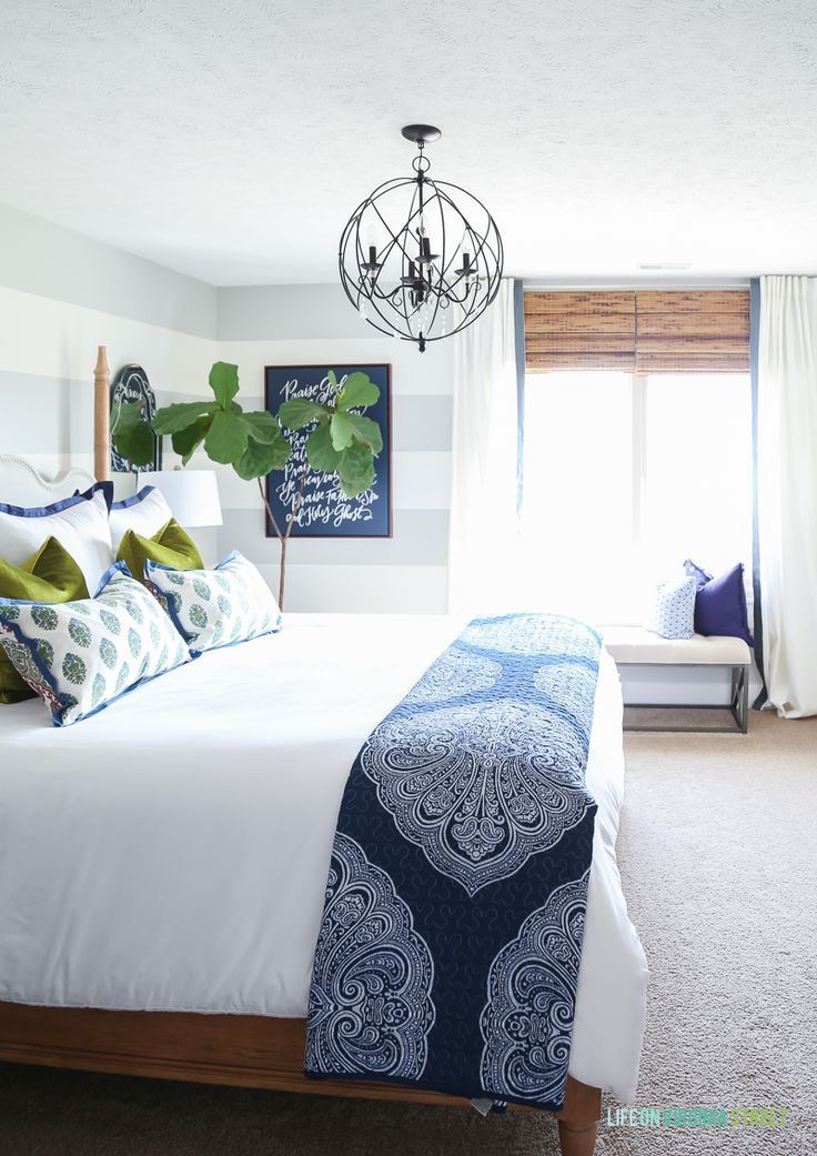 Guest bedroom with woven shades, ribbon trimmed drapes, white bedding, navy blue...