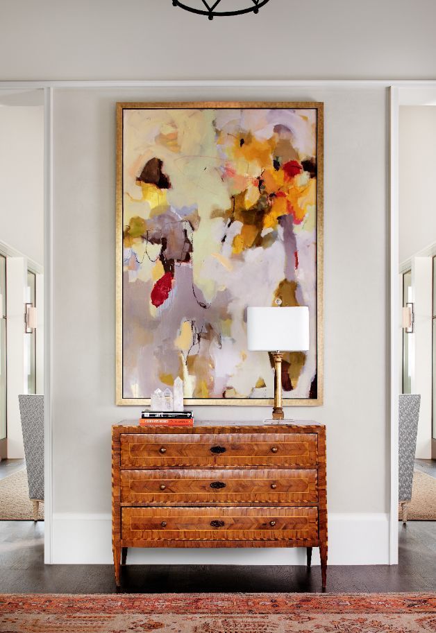 A Polished wooden cabinet, stylish artwork and golden trimming make this entrywa...
