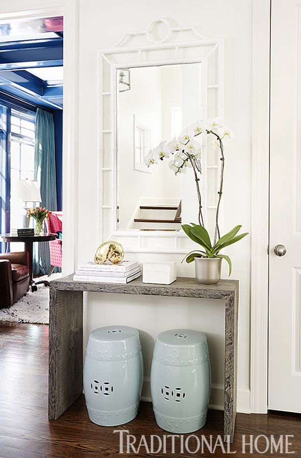 A custom console and garden stools create a cozy moment in the entry. - Photo: W...