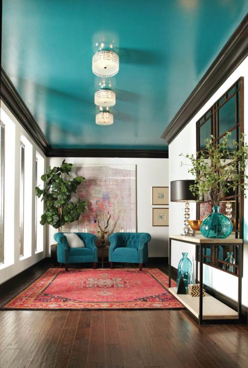 Bold ceiling in teal repeated in chairs and accessories