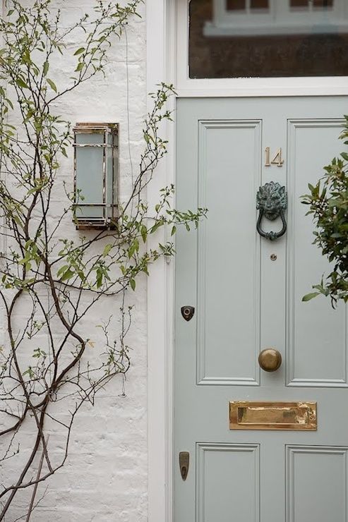pale blue door with brass numbers/hardware