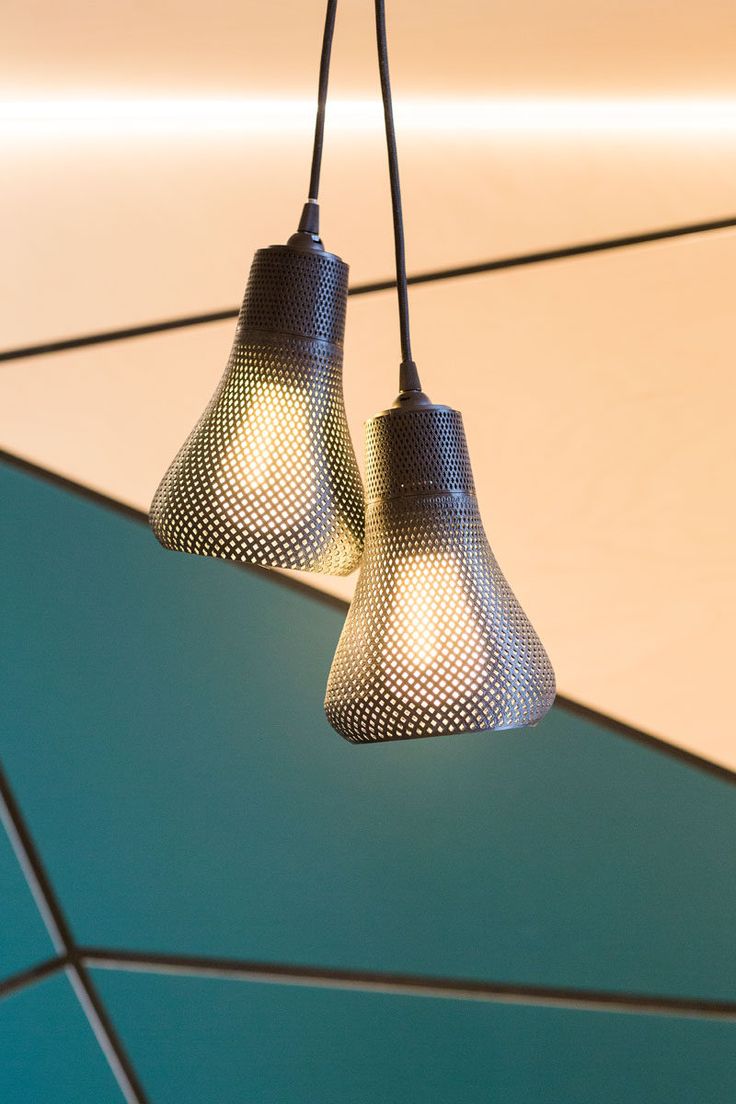 The lights hanging above the tables in this cafe are pairs of Kayan pendants fro...