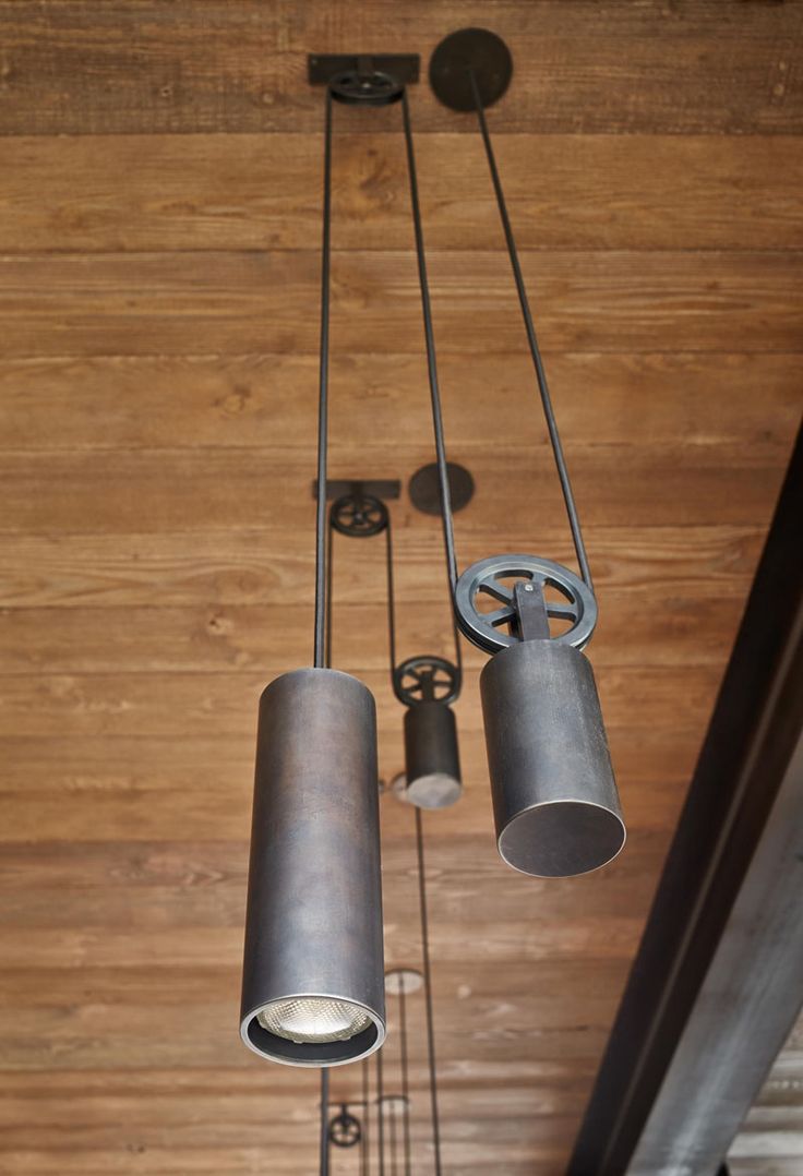 These industrial steel pendant lights are hung using a pulley system.