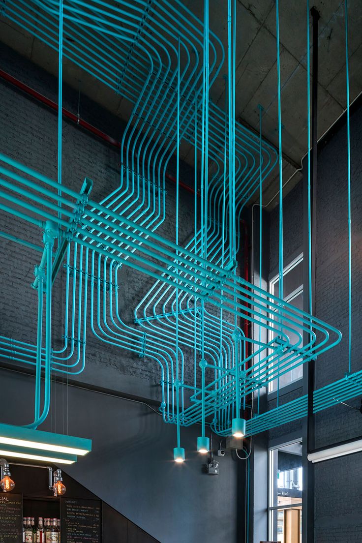 Turquoise electrical conduit is a design feature running through this office spa...