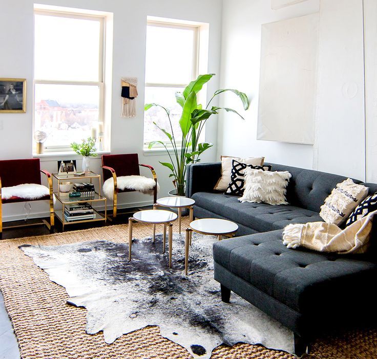 Gray sofa with modern coffee tables, cowhide rug, and indoor plants. I love the ...