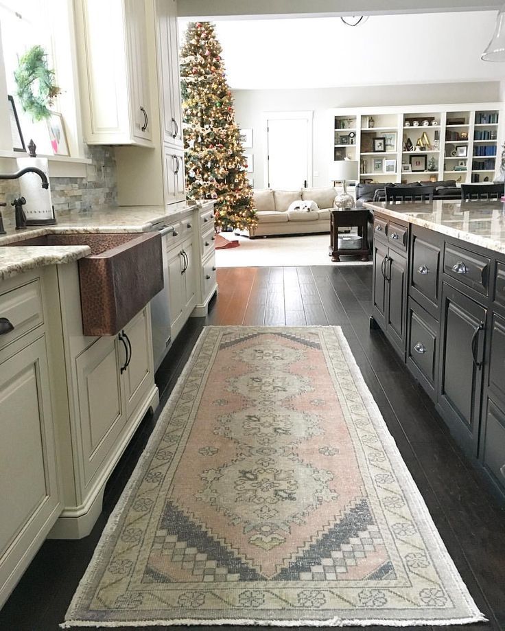 Neutral kitchen with copper farmhouse sink and vintage oushak rug. Two-toned kit...