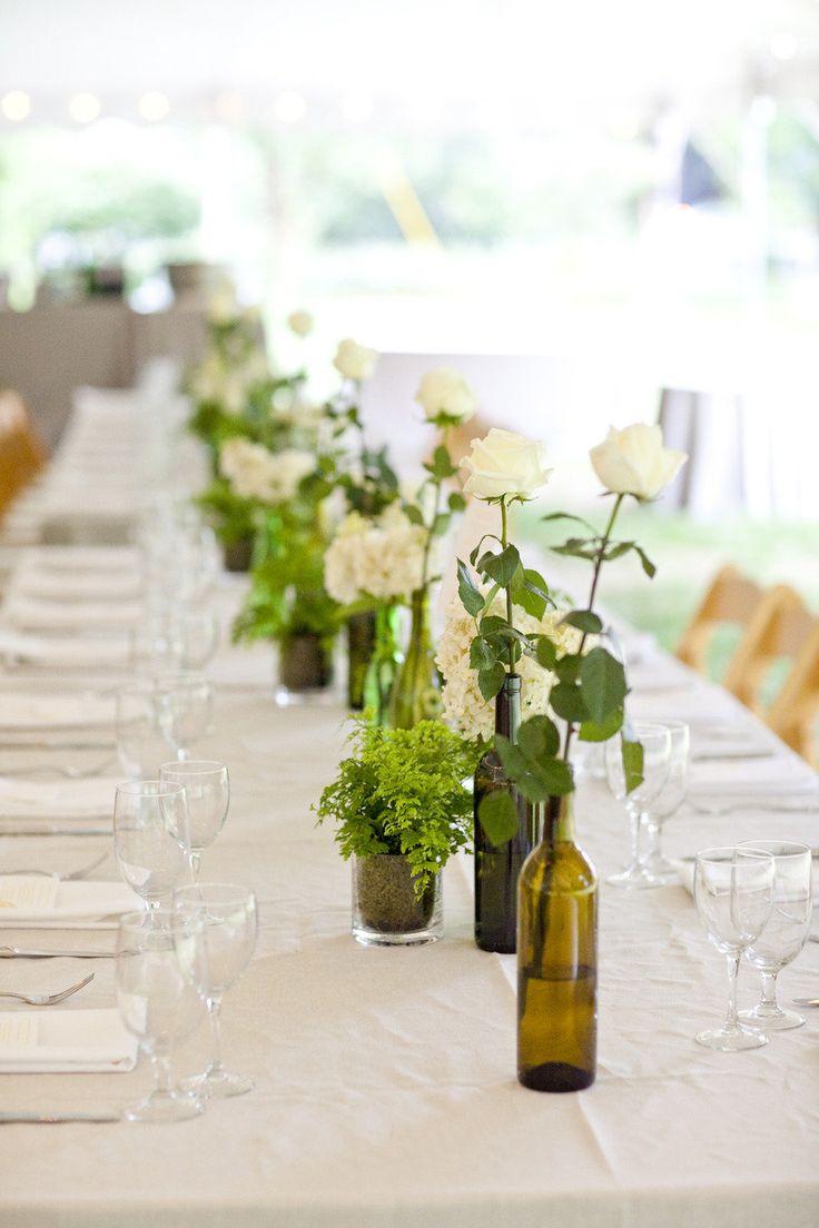 Wine bottles as vases for centerpieces.    Photo:  Mel & Co.