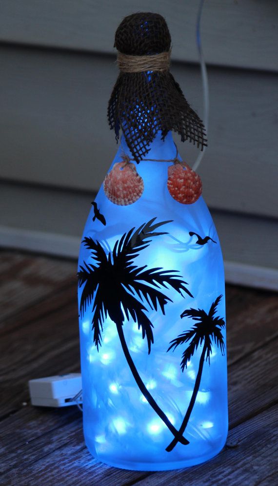 Beautiful wine bottle decorated with vinyl palm trees and birds, while seashells...