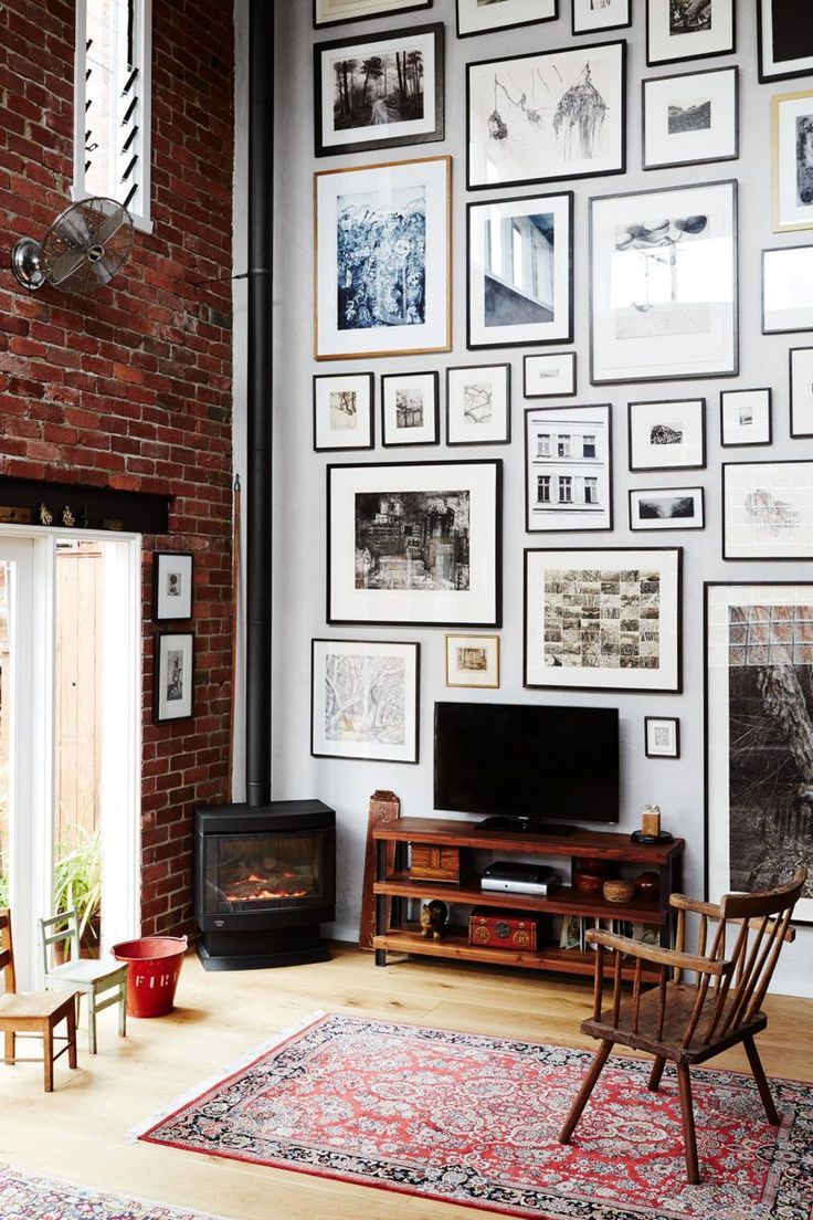Living space with high ceilings, exposed brick and a gallery wall in an Australi...