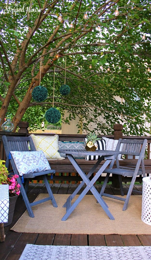 An eclectic and cozy backyard deck tucked into the branches of a tree. Perfect f...