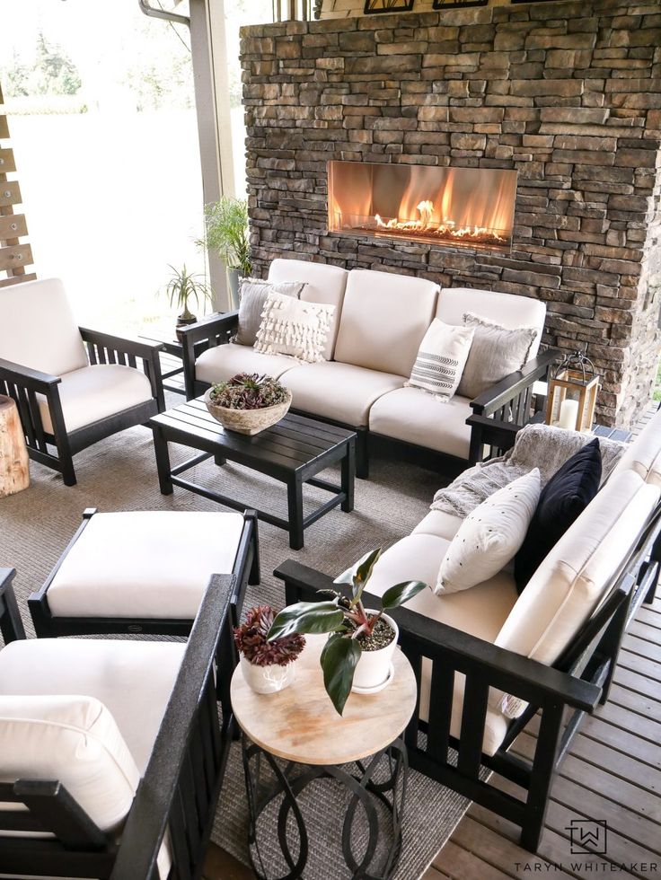 Luxurious outdoor living space with outdoor stone fireplace and beautiful black ...