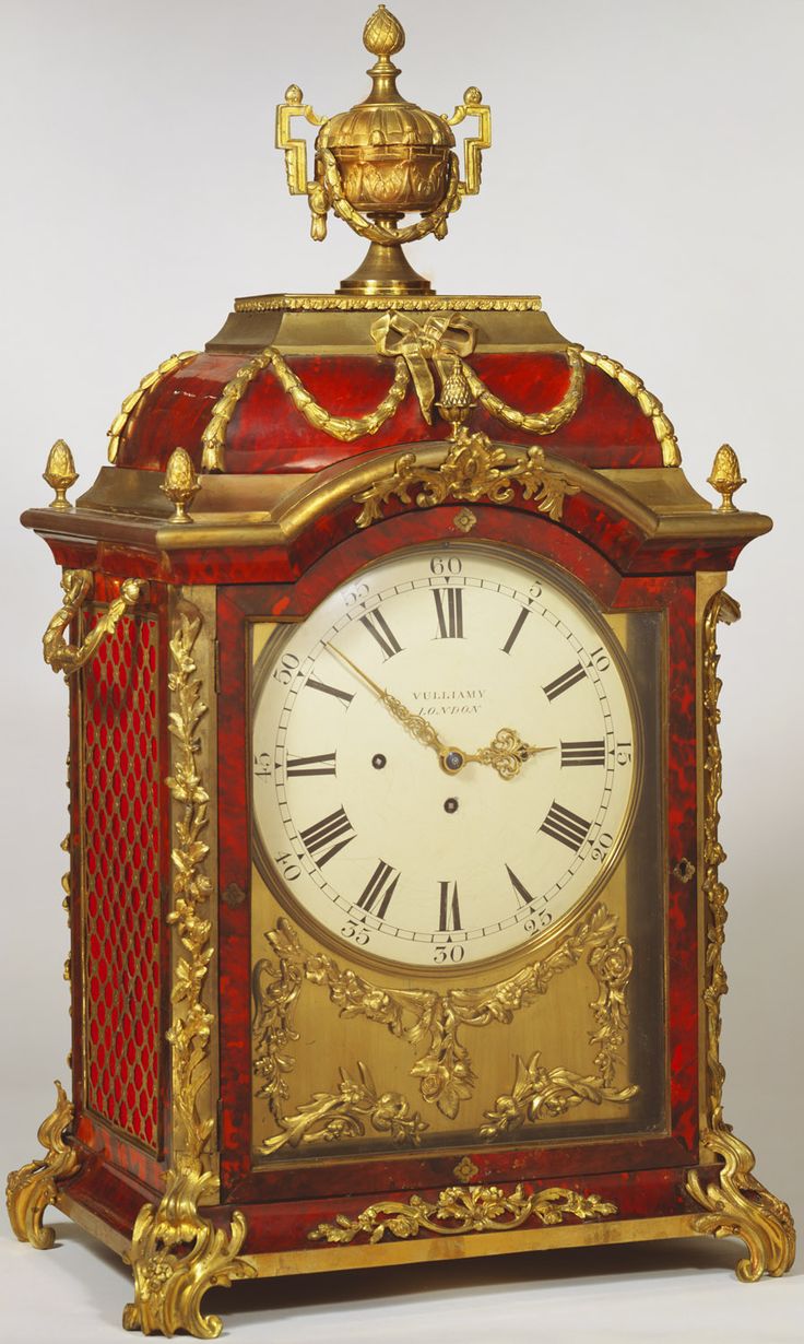 A bracket clock with a broken arch, of tortoishell and ormolu and surmounted by ...