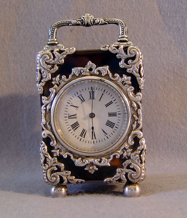 A fine small antique English silver mounted tortoiseshell carraige clock. Silver...