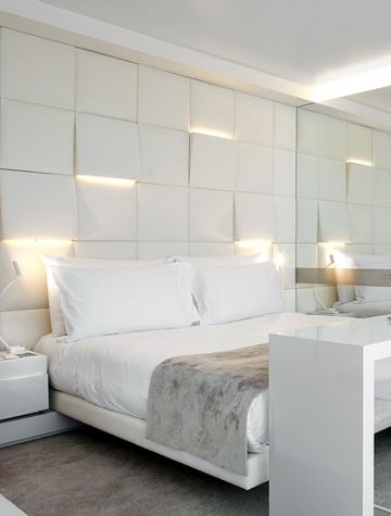 Lighting: uplights and downlights integrated into sculpture squares headboard be...