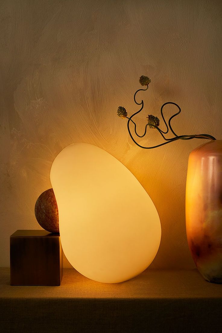 For the Dimple Lamp, a carved marble sphere nestles in an impression in the glas...