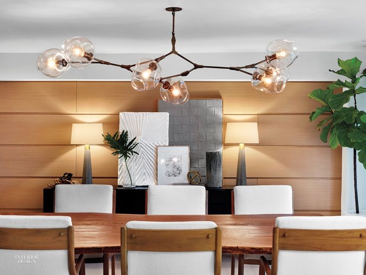Lindsey Adelman Studio’s chandelier presides over a custom dining table in whi...