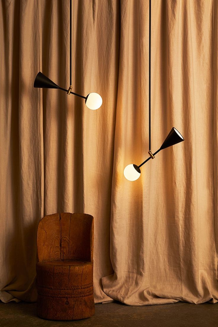 Small Spear Pendant Lights are balanced by a satin black cone light source at on...