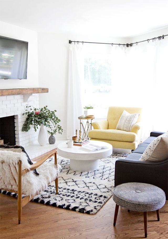 Modern bohemian-meets-midcentury living room with a Moroccan rug, sheepskin arm ...