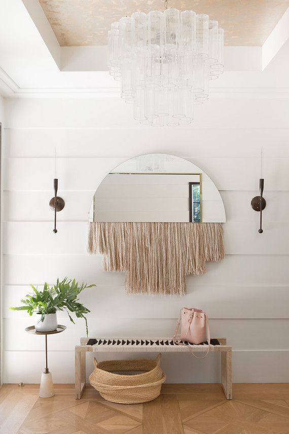 modern boho entryway with bench, fringe mirror and statement chandelier