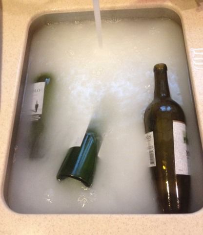 Fill your sink with hot, hot, hot water.  Then fill each wine bottle with hot wa...