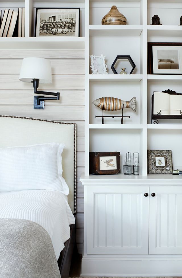 Cottage bedroom.  stylish built-ins + paneled wall behind bed